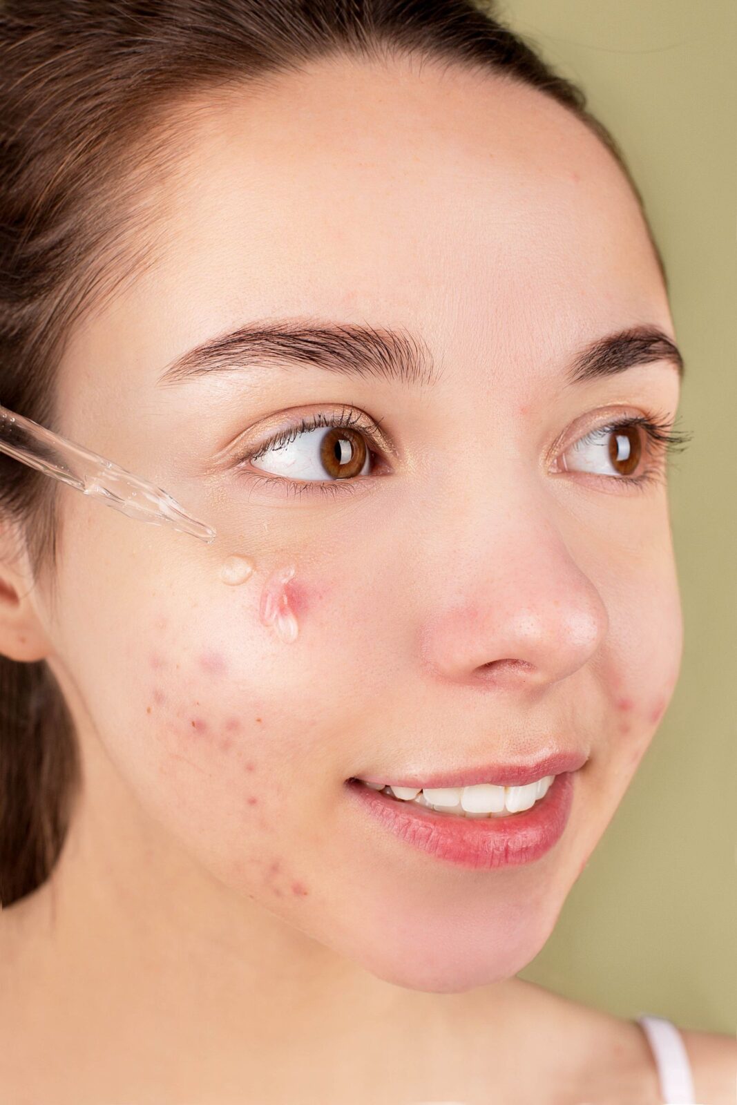 Woman applying facial serum as part of her skincare routine