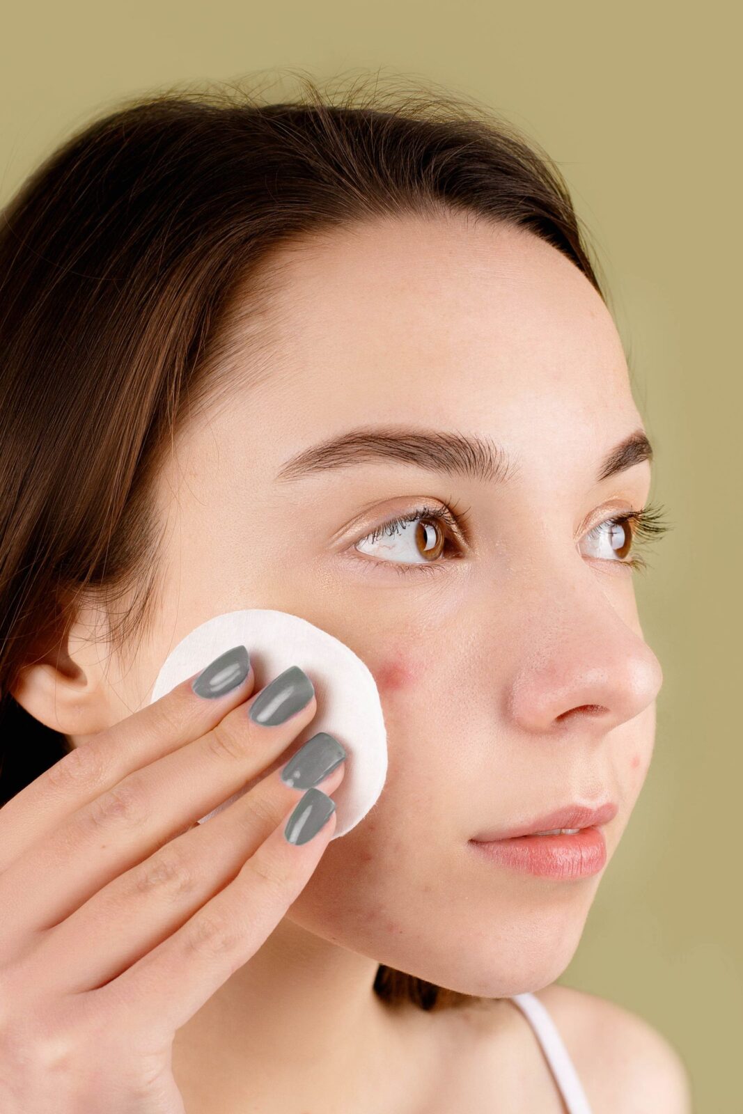 A woman gently massaging a creamy cleanser onto her skin