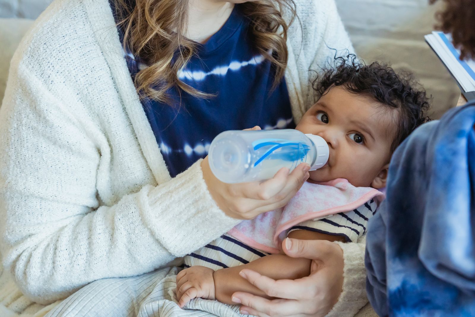Parent feeding a baby from a bottle