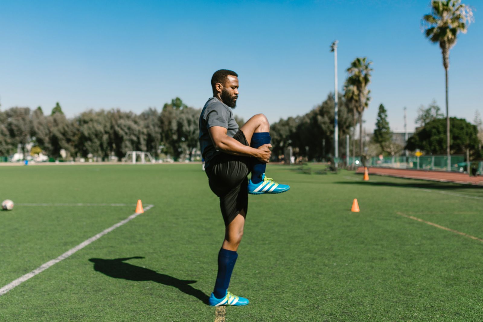 Athlete stretching leg muscles outdoors after a training session