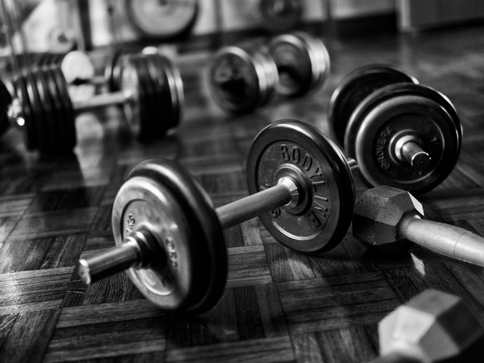 A set of dumbbells resting on the floor of a home gym