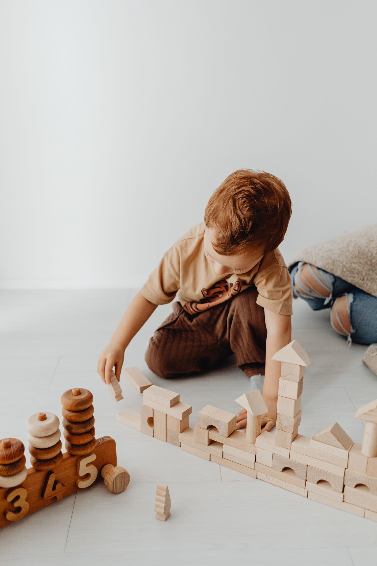 Child's hands stacking wooden building blocks while playing