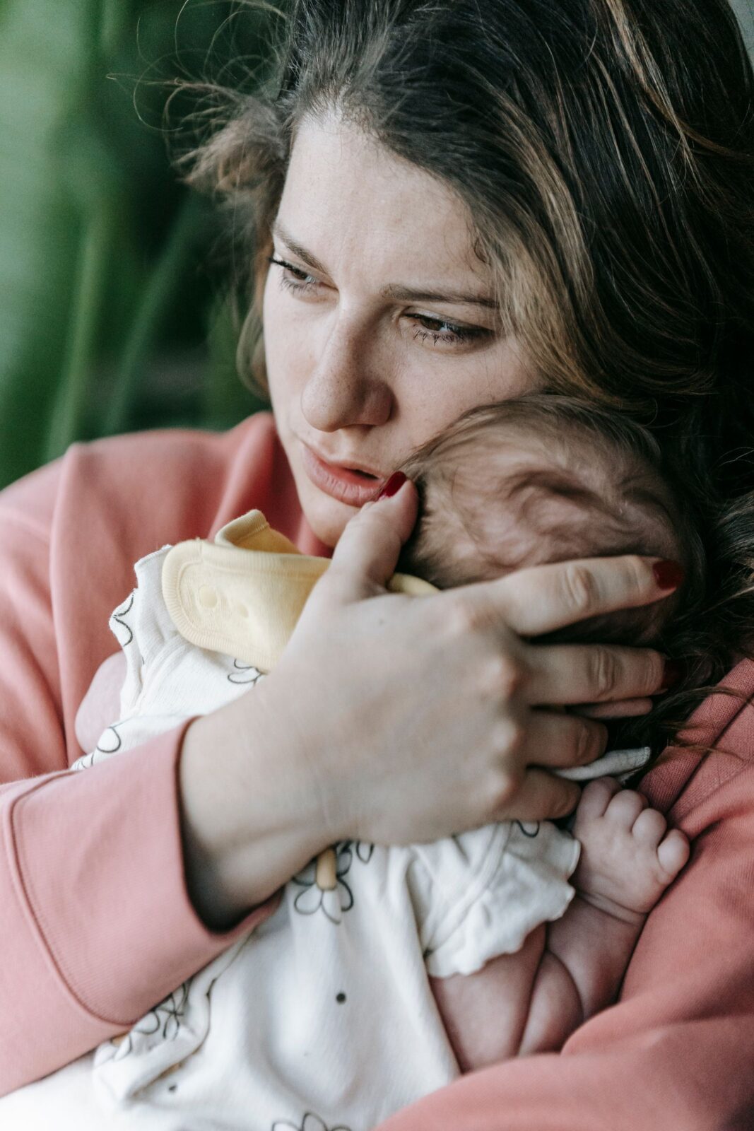 A mother comfortably feeding her newborn in a nursery chair