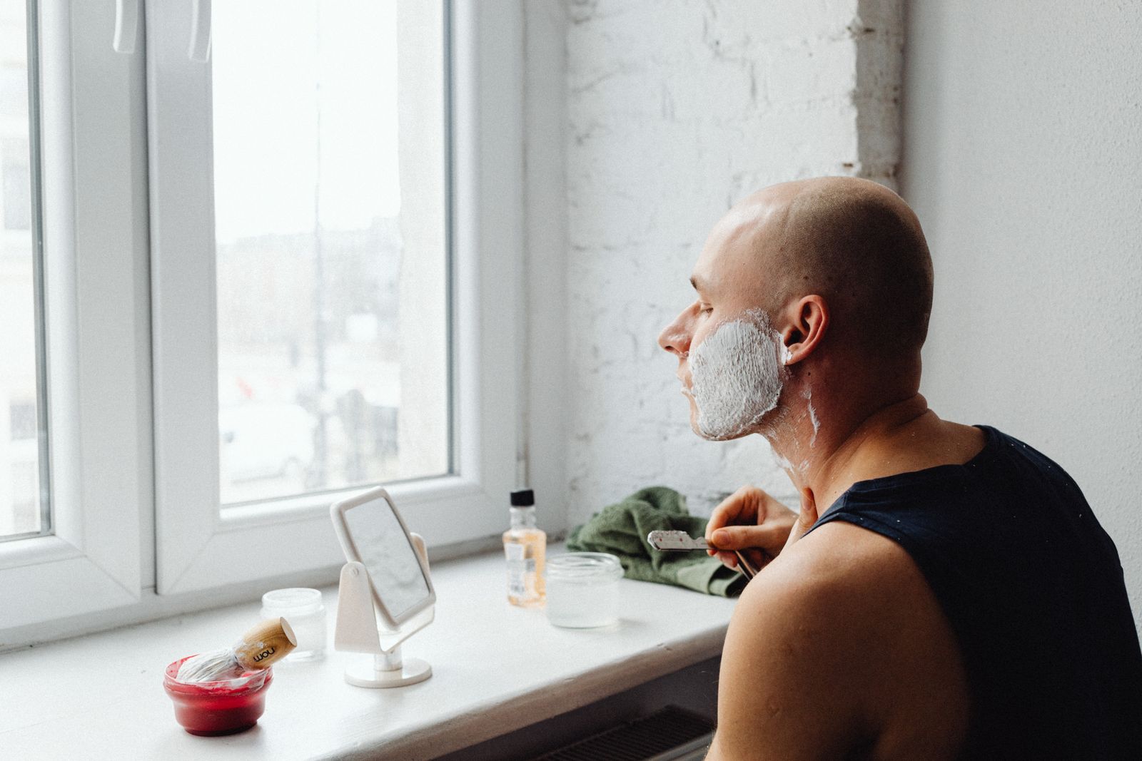 Man following a morning grooming routine in a bright bathroom