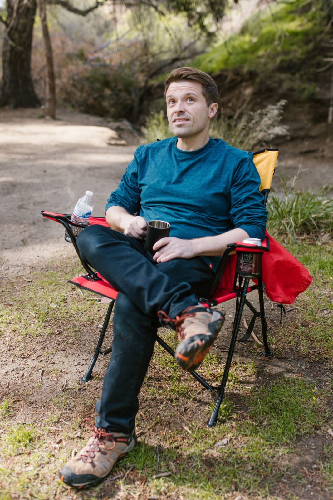 A man sitting on a lightweight camping chair outdoors