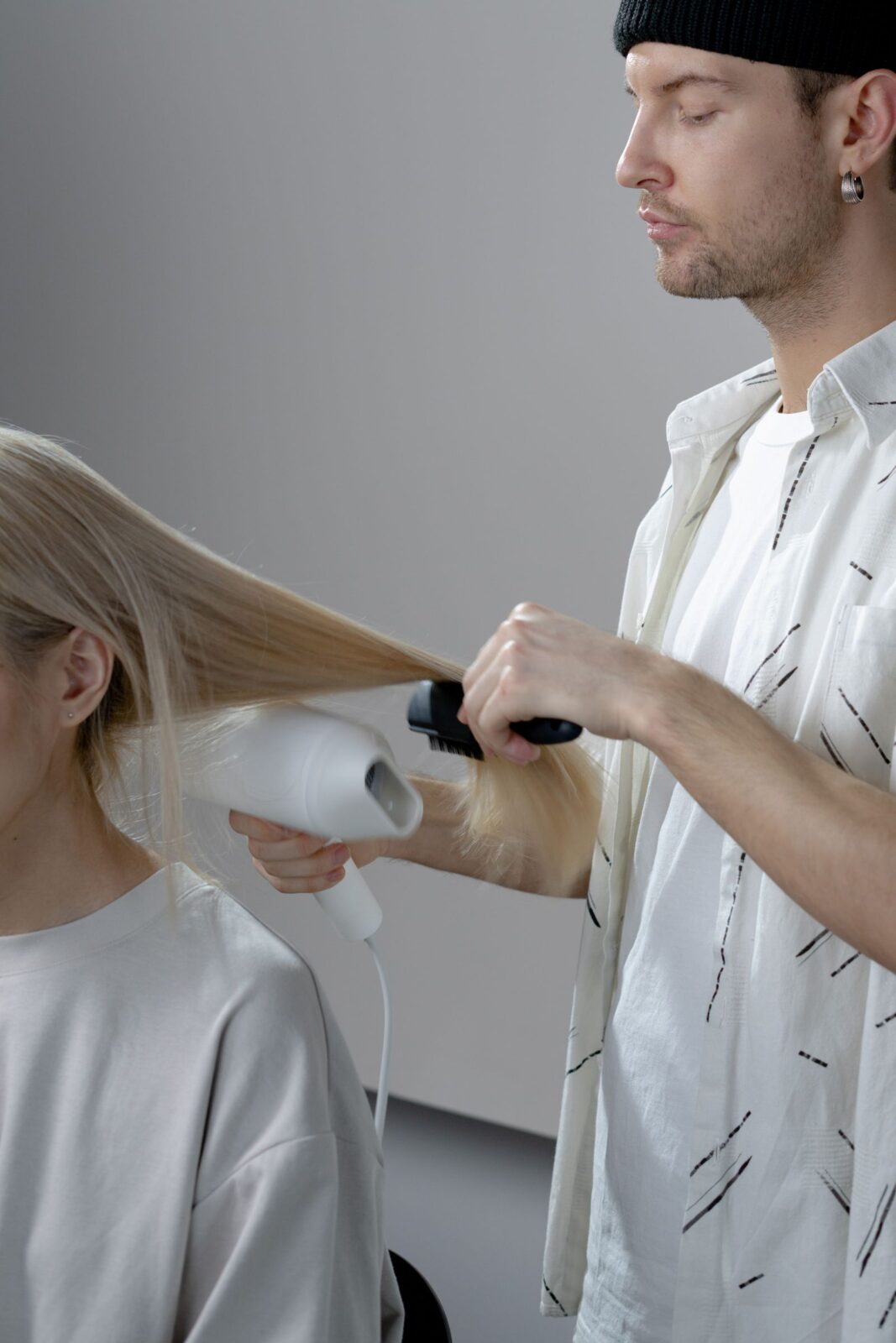 A stylist blow drying a client's hair for a smooth blowout