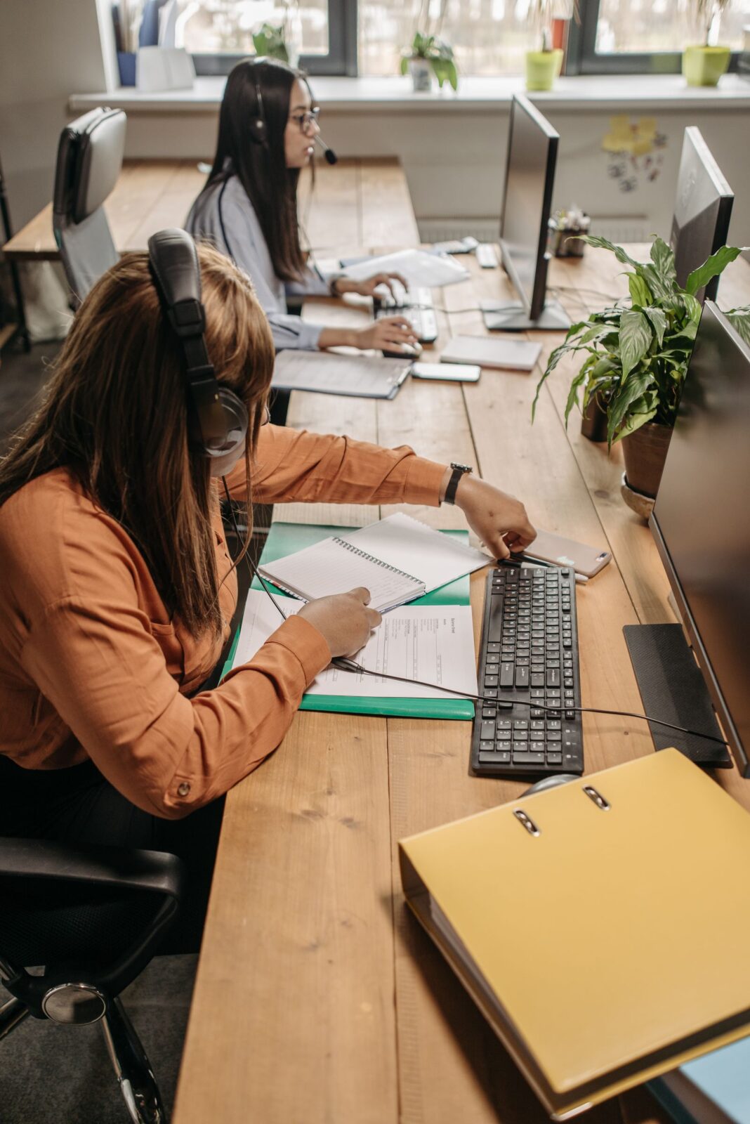 A person wearing headphones working at a desk with a laptop