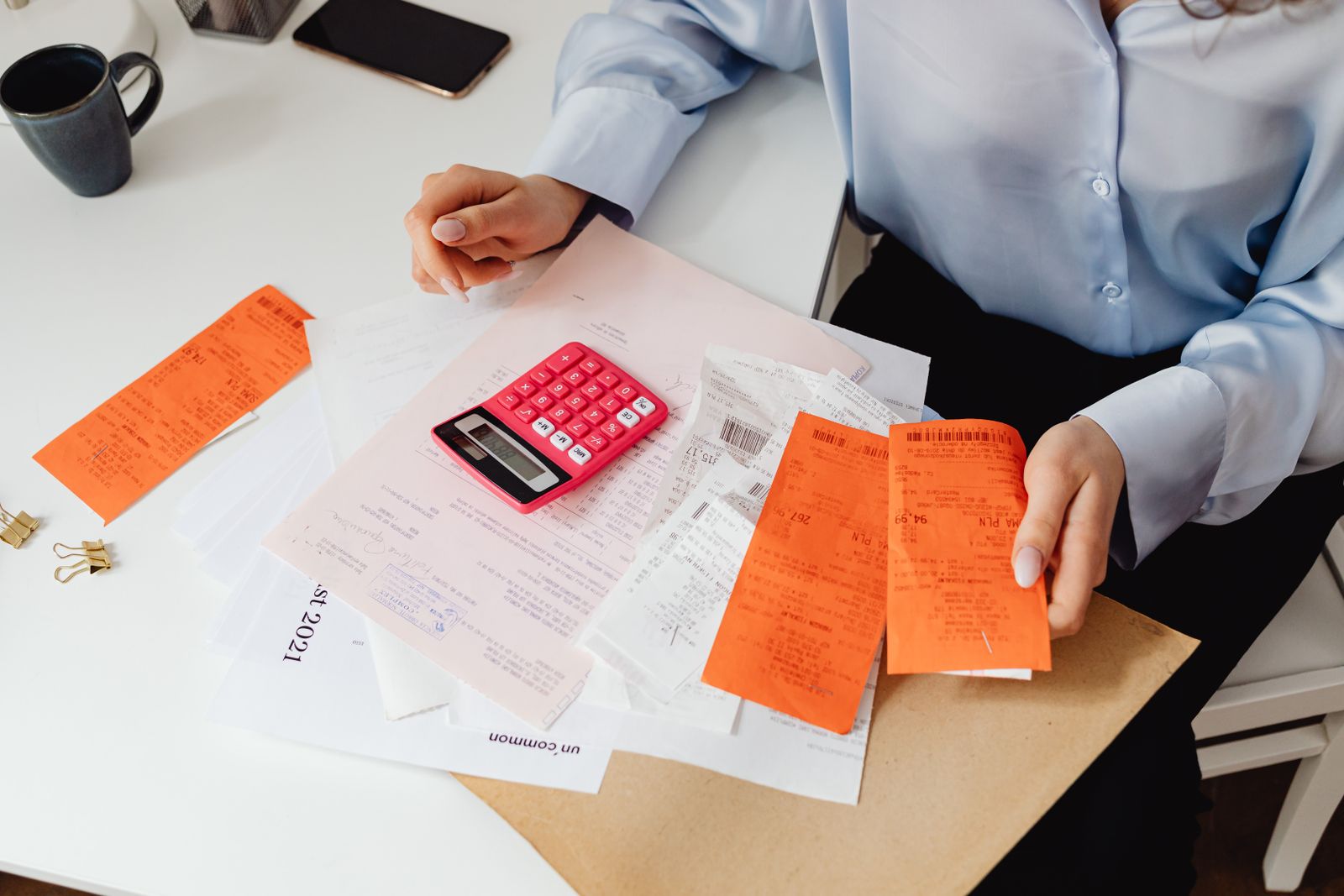 A person calculating healthcare costs with a calculator and insurance card