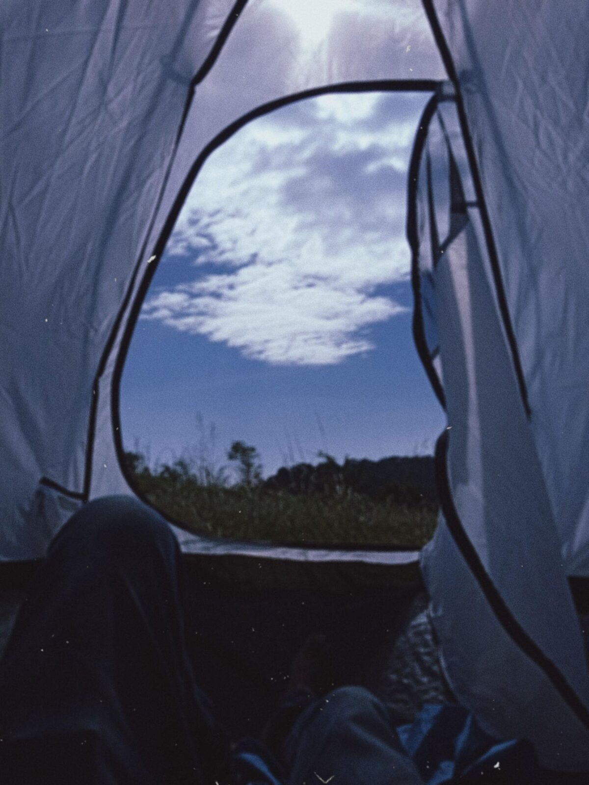A sleeping bag and pad inside a camping tent in morning light