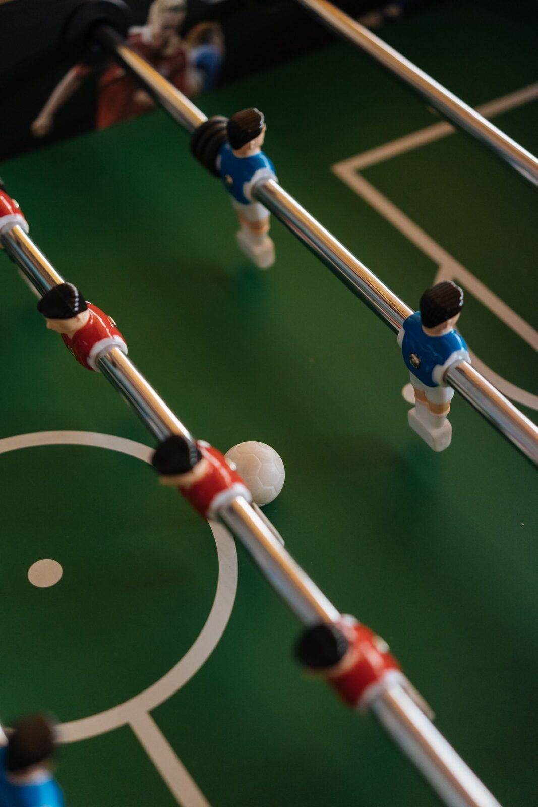 Foosball table with rows of red and blue player figures, set up for a head-to-head match