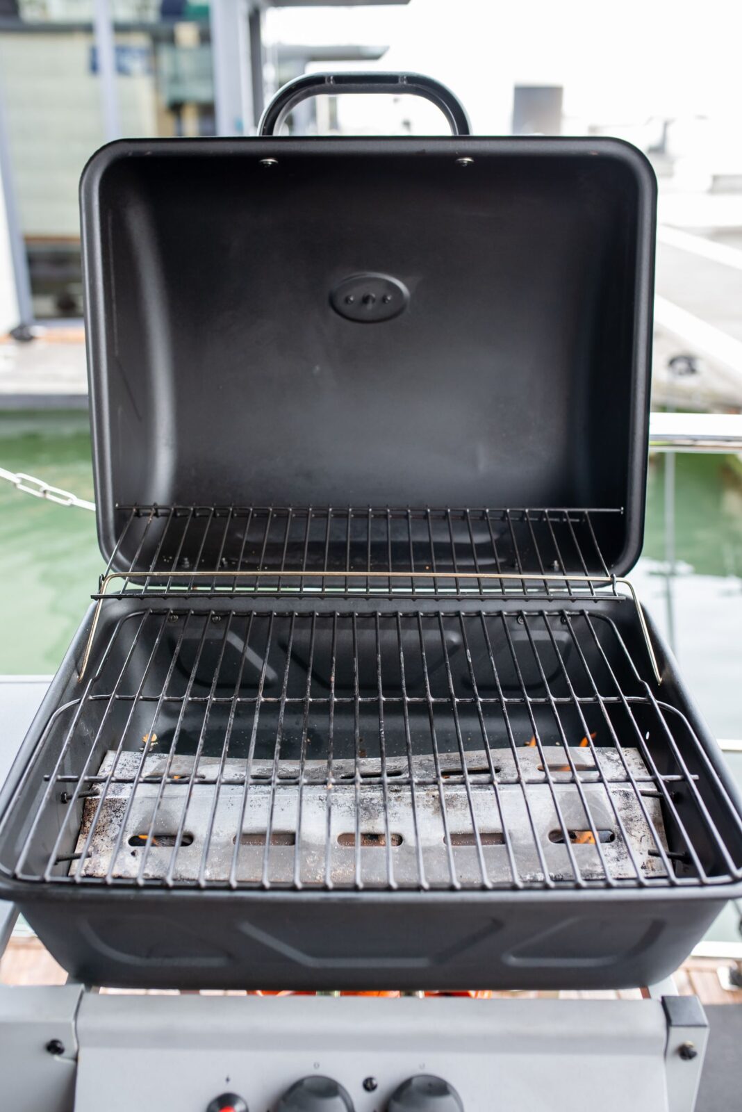 A compact portable grill cooking outdoors on a sunny patio