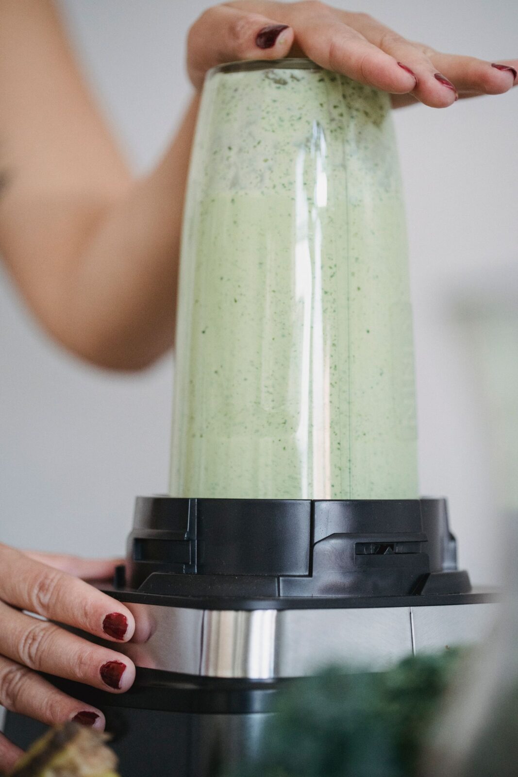 A person making a smoothie using a blender in the kitchen