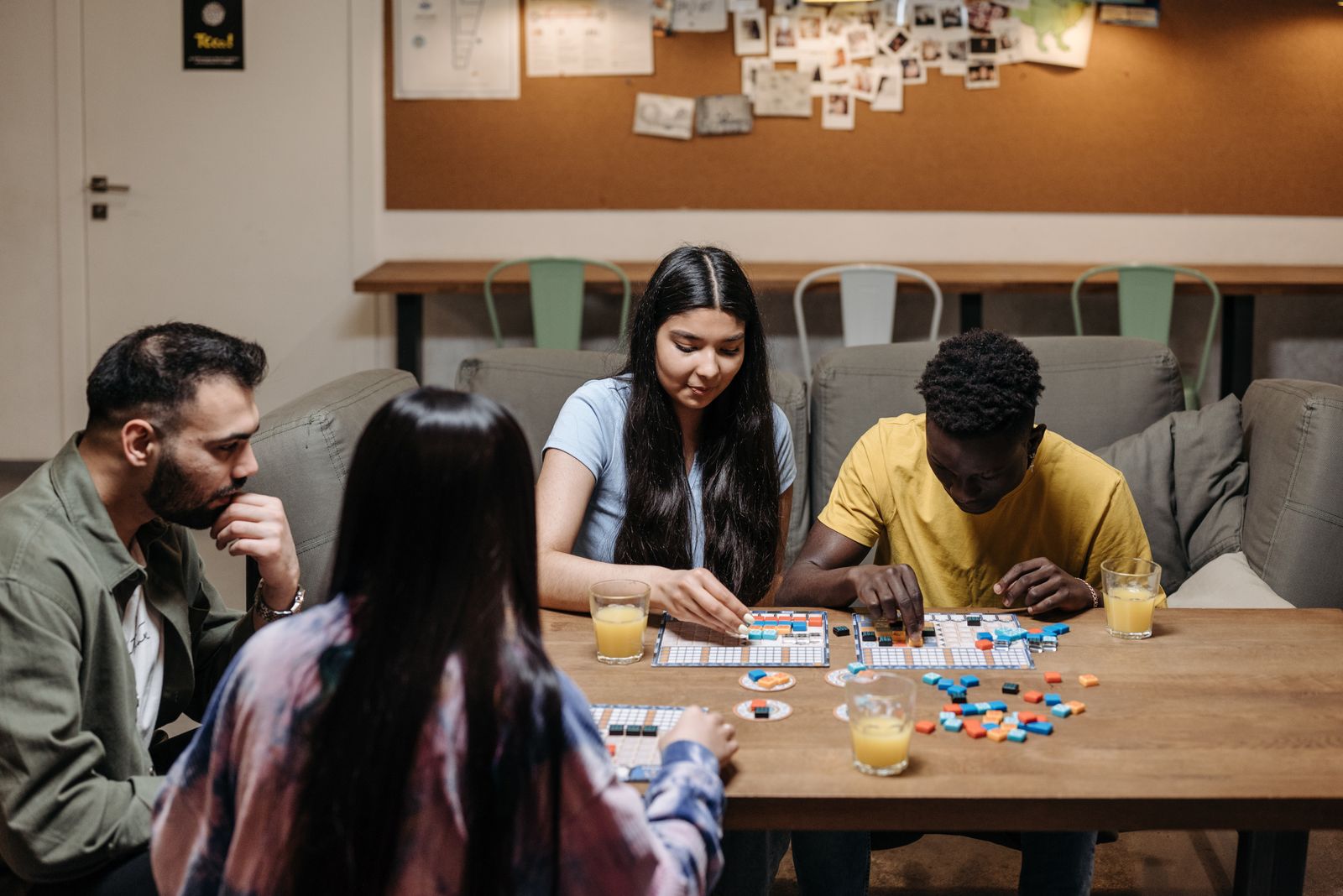 A multi-generational family playing a board game together at a table