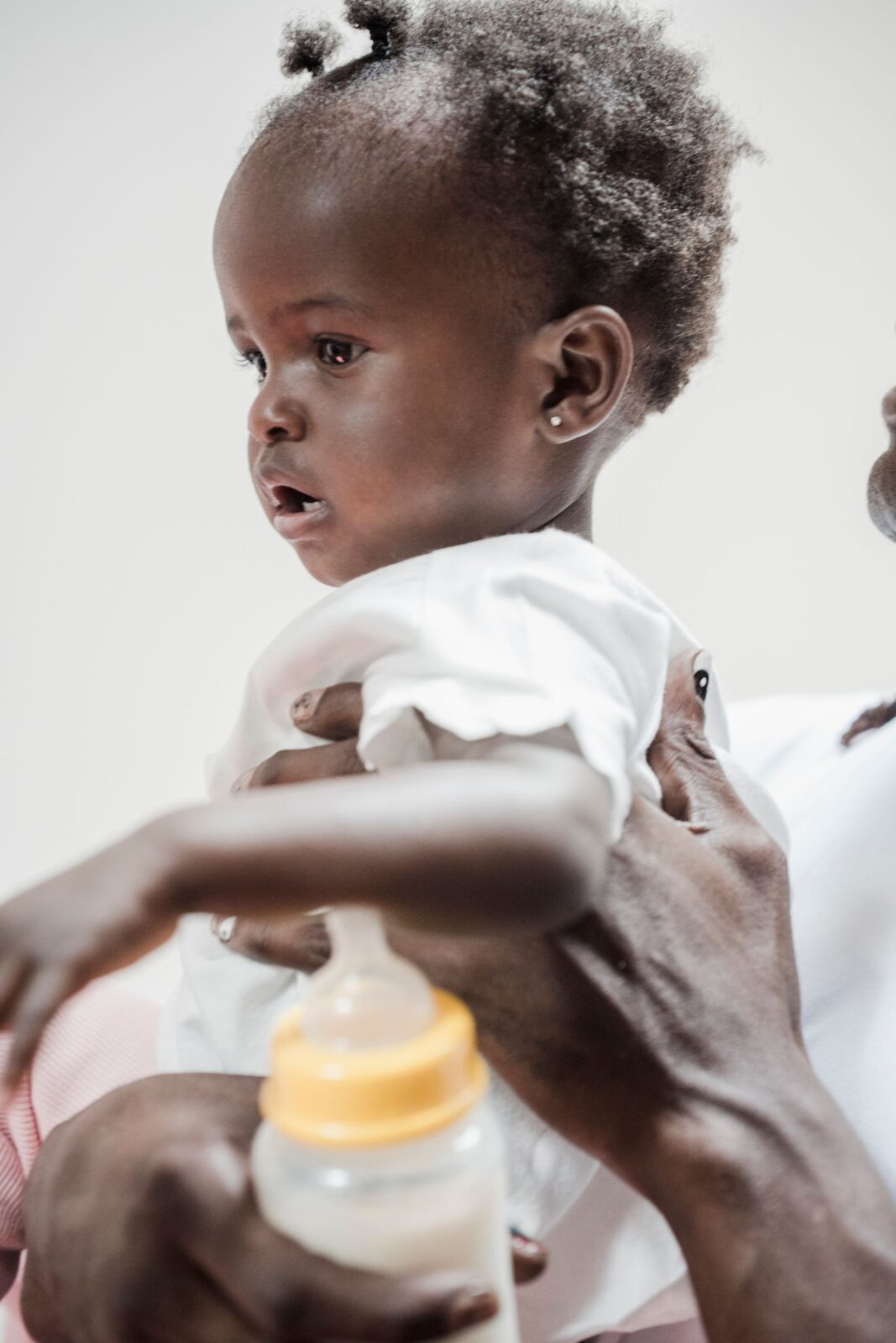 A baby holding a soft silicone bottle with both hands