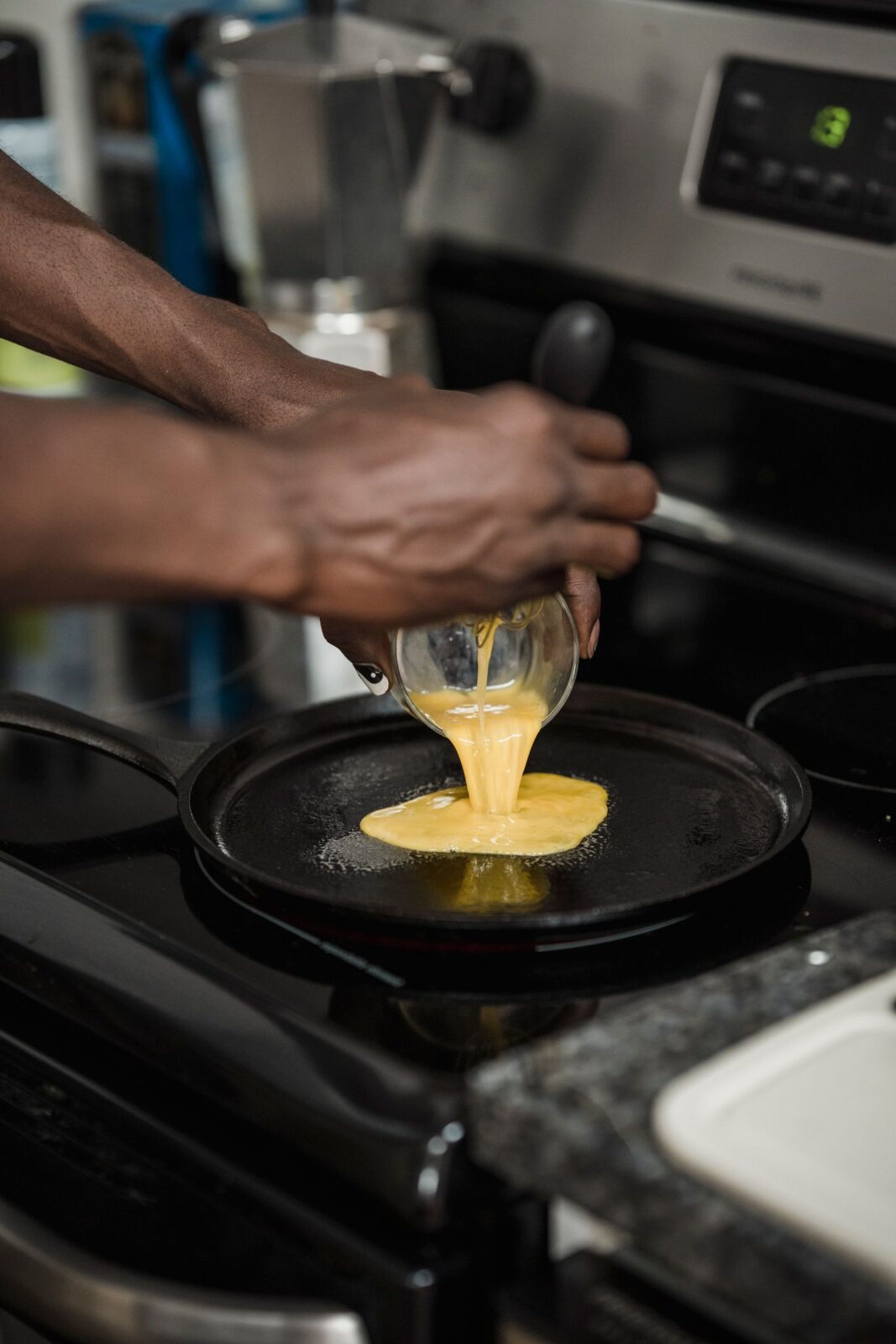 A person cooking scrambled eggs in a nonstick frying pan