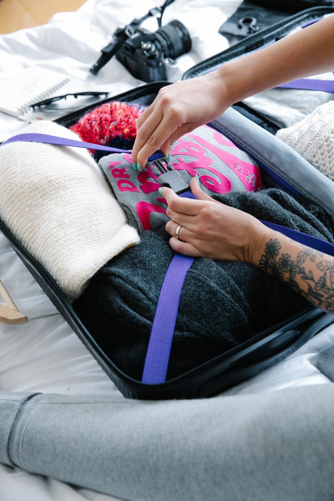 Packing a suitcase with folded travel clothing before a long trip
