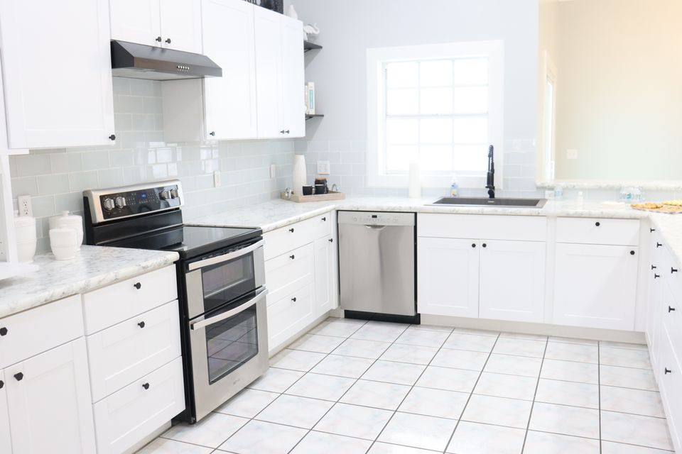 Bright modern kitchen with white cabinets and countertop appliances