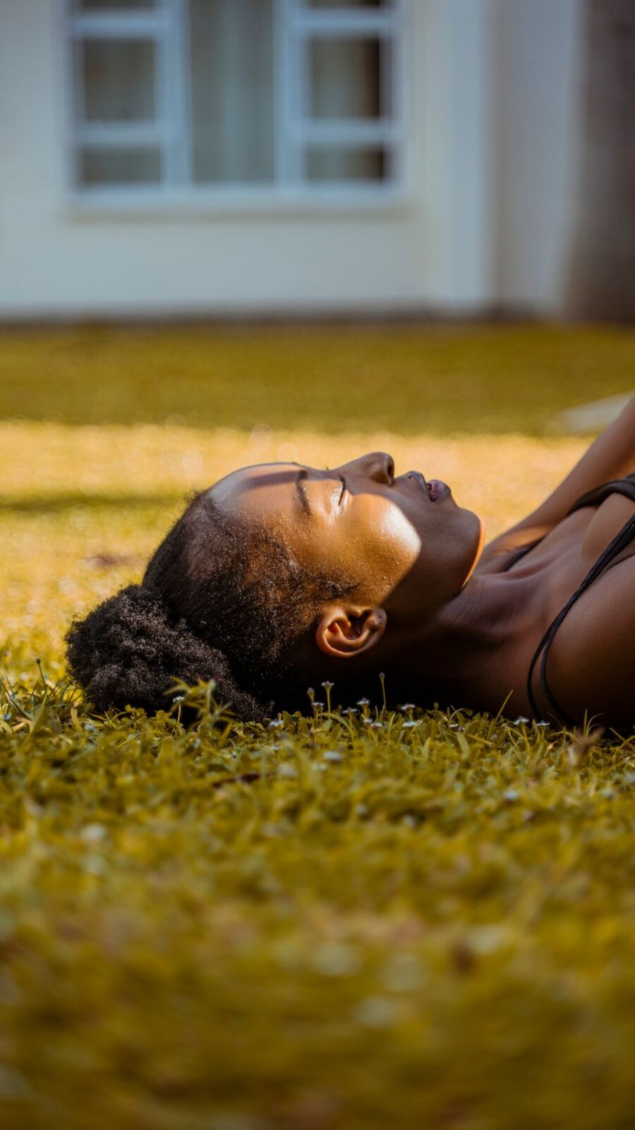 A serene portrait of a woman lying on the grass, enjoying a peaceful moment of relaxation