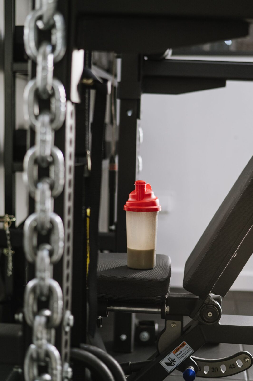 Protein shaker bottle resting on gym equipment