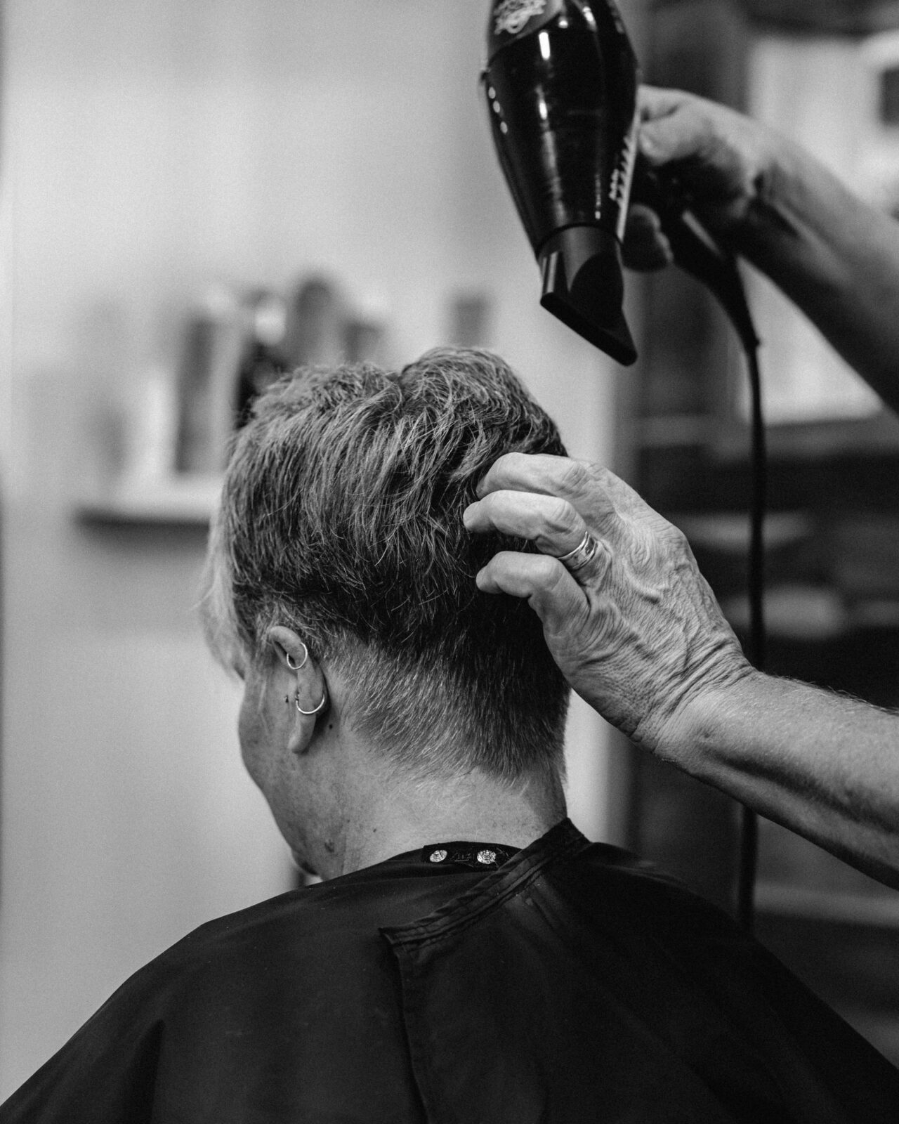 Hairdresser blow-drying a client's hair in a salon