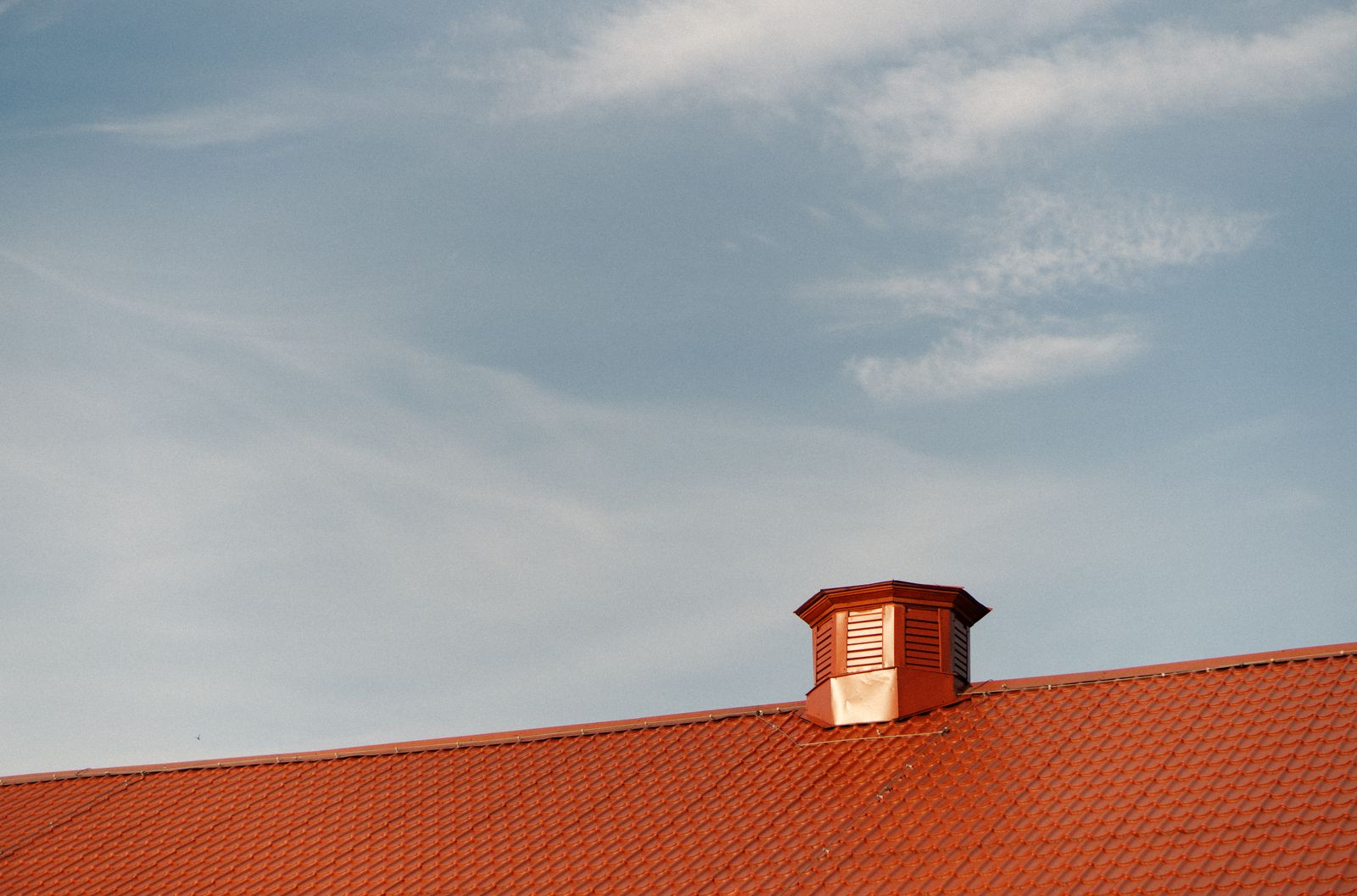 A roof vent on a metal rooftop, the kind of vent a whole-house fan exhausts hot attic air through