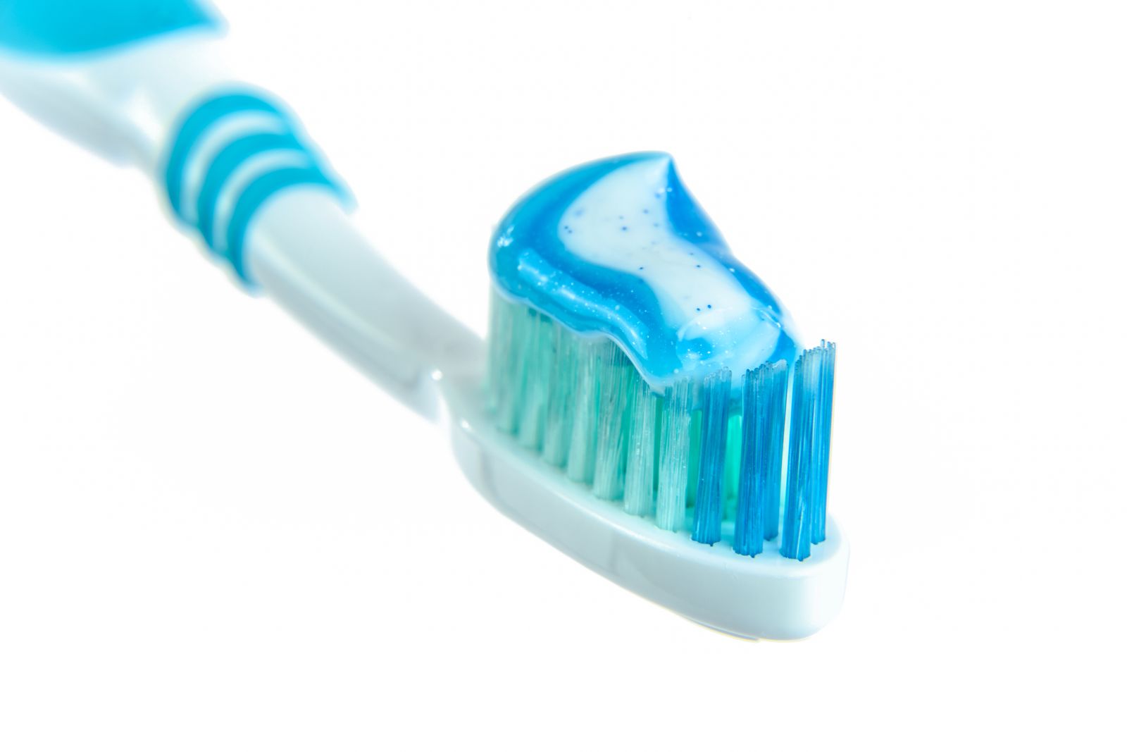Close-up of toothpaste applied to a toothbrush head before brushing