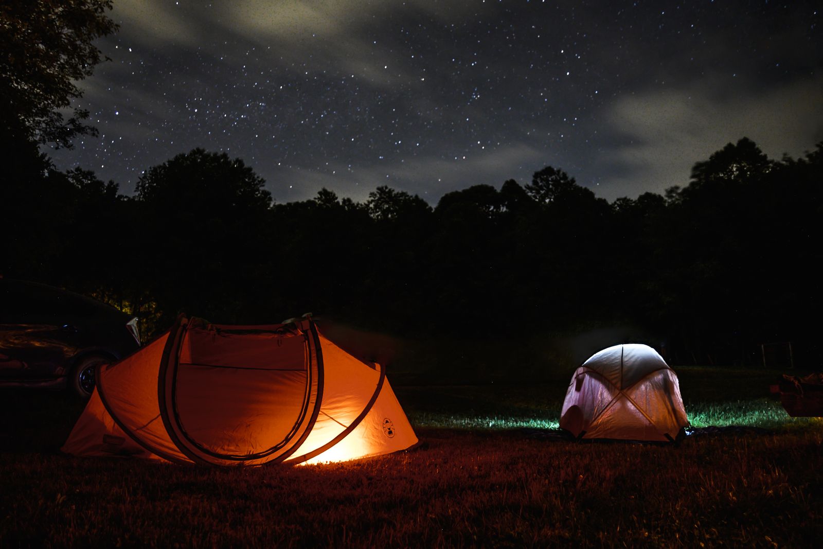 Tents pitched at a campsite under a night sky