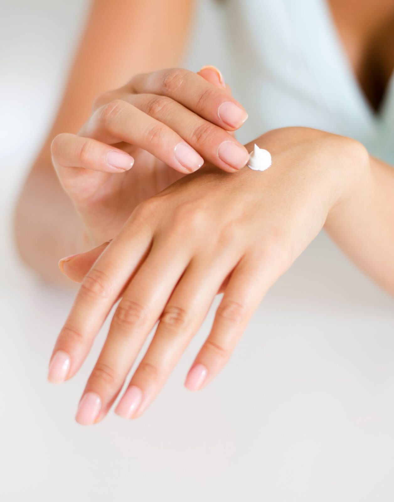 Close-up of hands applying a moisturizing lotion to skin