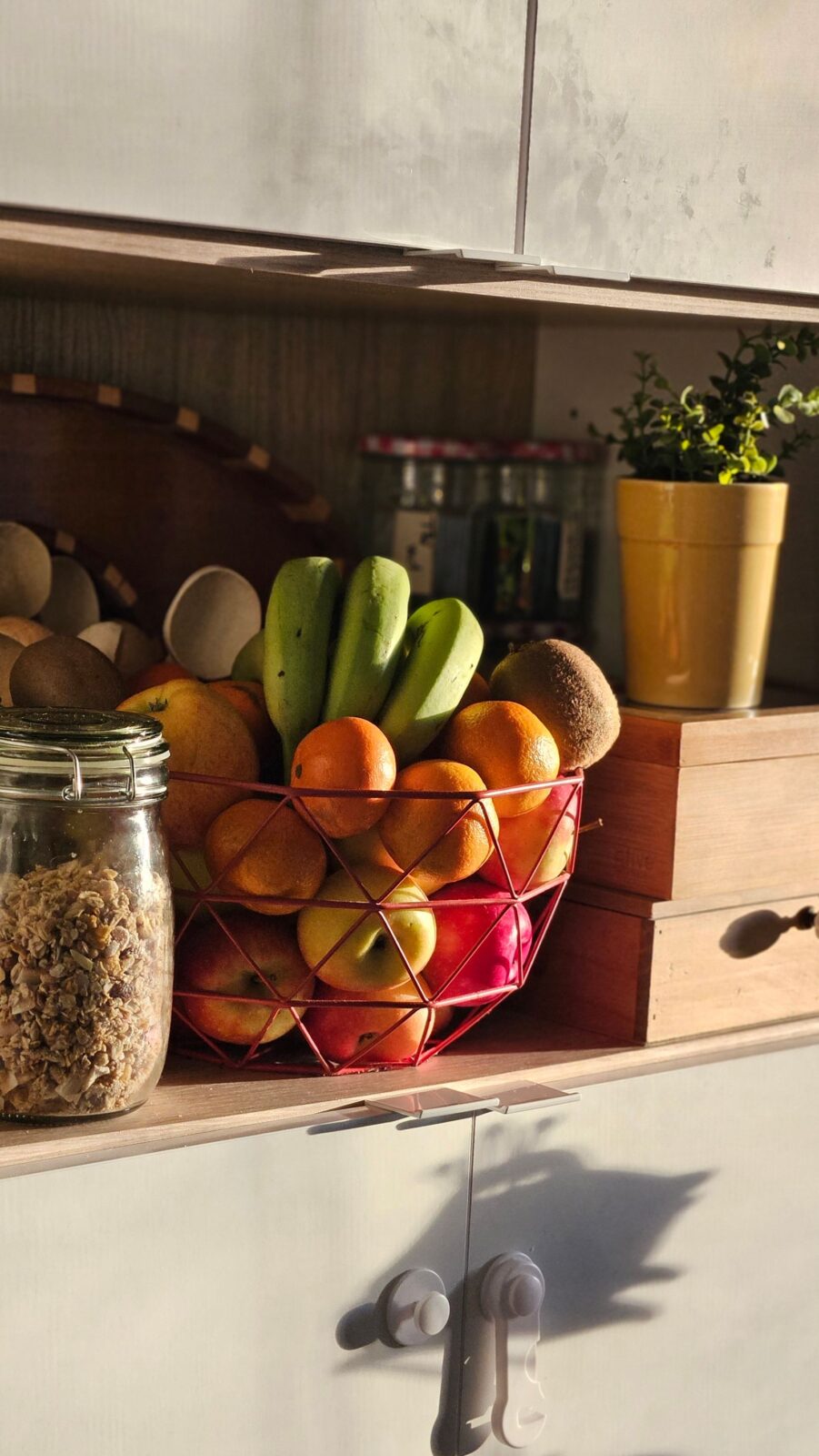 Fresh fruit and granola arranged on a kitchen counter, the kind of everyday ingredients used in a quick daily smoothie
