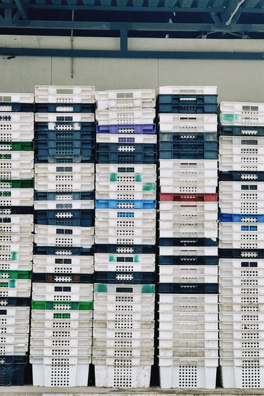 Stacks of colorful plastic storage crates in a storage area
