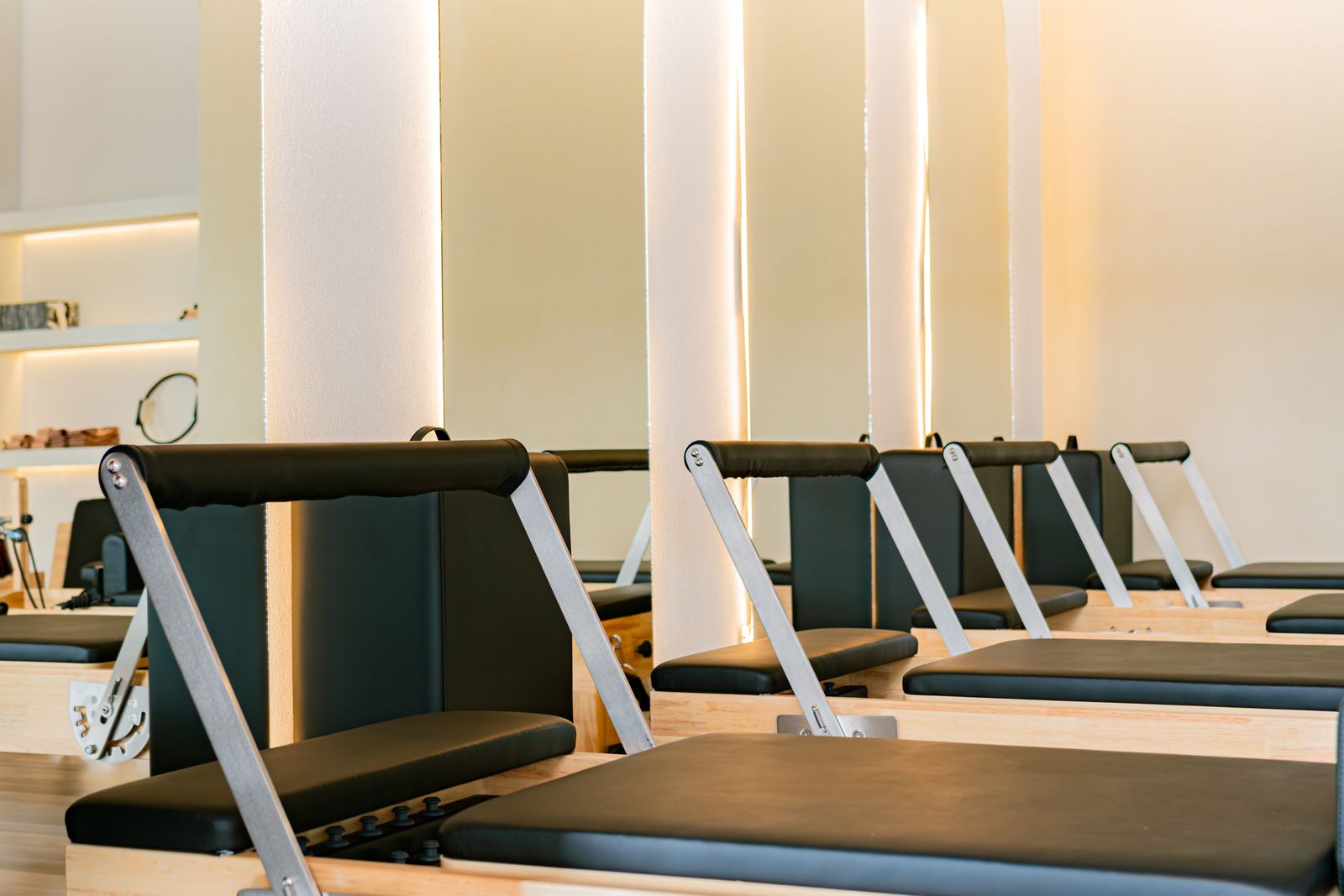 Multiple Pilates reformer machines lined up in a modern studio space