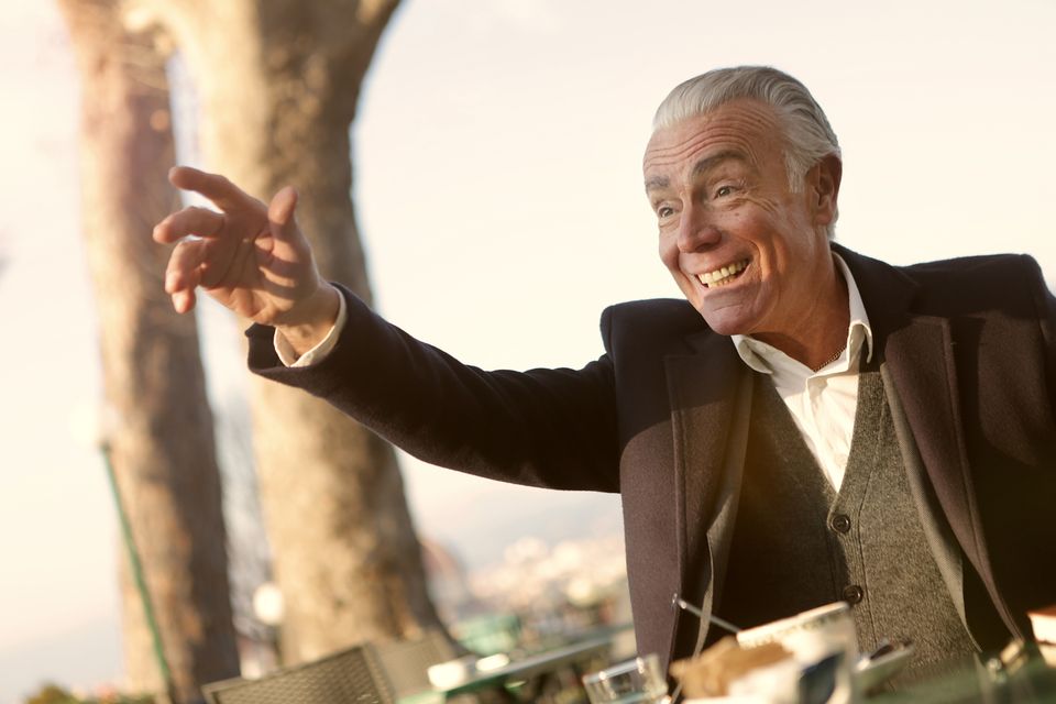 Cheerful senior man enjoying a sunny day outdoors with a smile