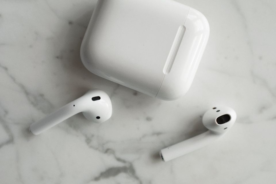 Wireless earbuds and charging case on a marble surface