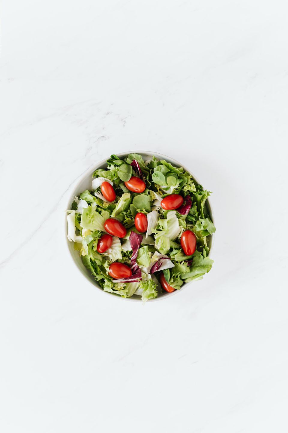 Bowl of fresh vegetable trimmings on a kitchen counter, the kind of daily scraps a countertop composter is designed to process
