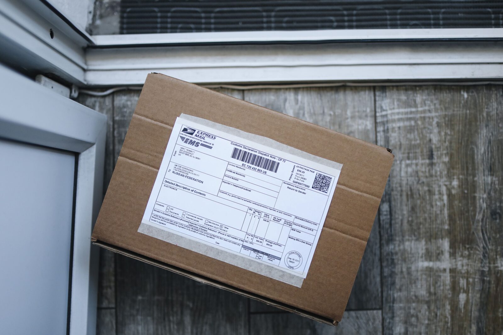 Cardboard package sitting on a front doorstep near an entry door