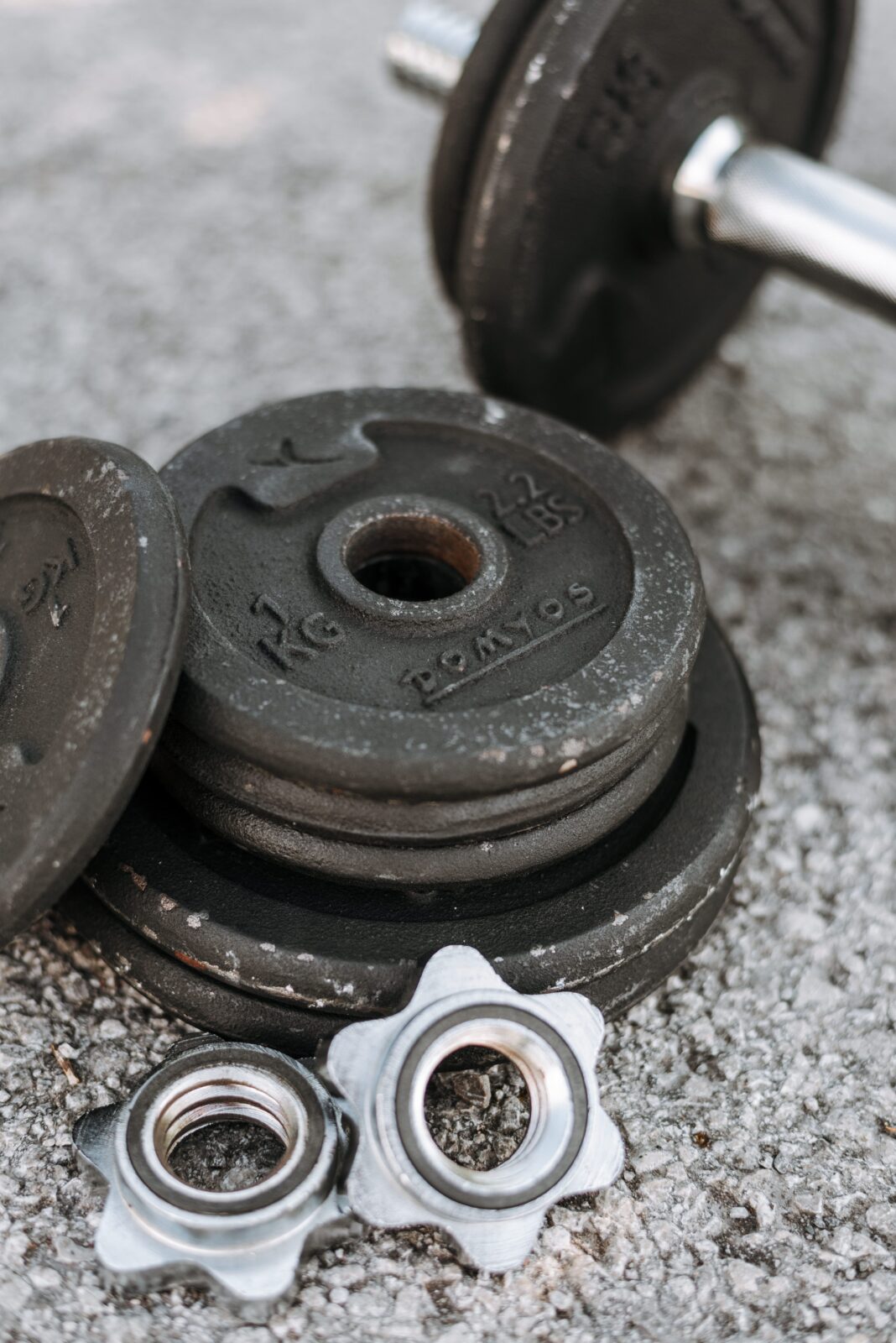 Adjustable dumbbell with weight plates and selector parts laid out on the ground