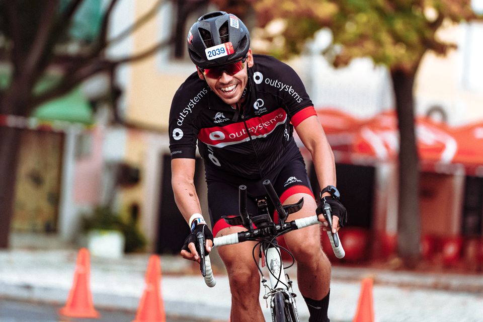Smiling cyclist in helmet racing on a road bike during a sunny day