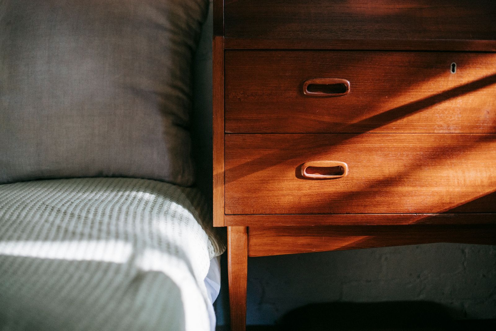 Interior of a contemporary cozy bedroom with a wooden nightstand near the bed
