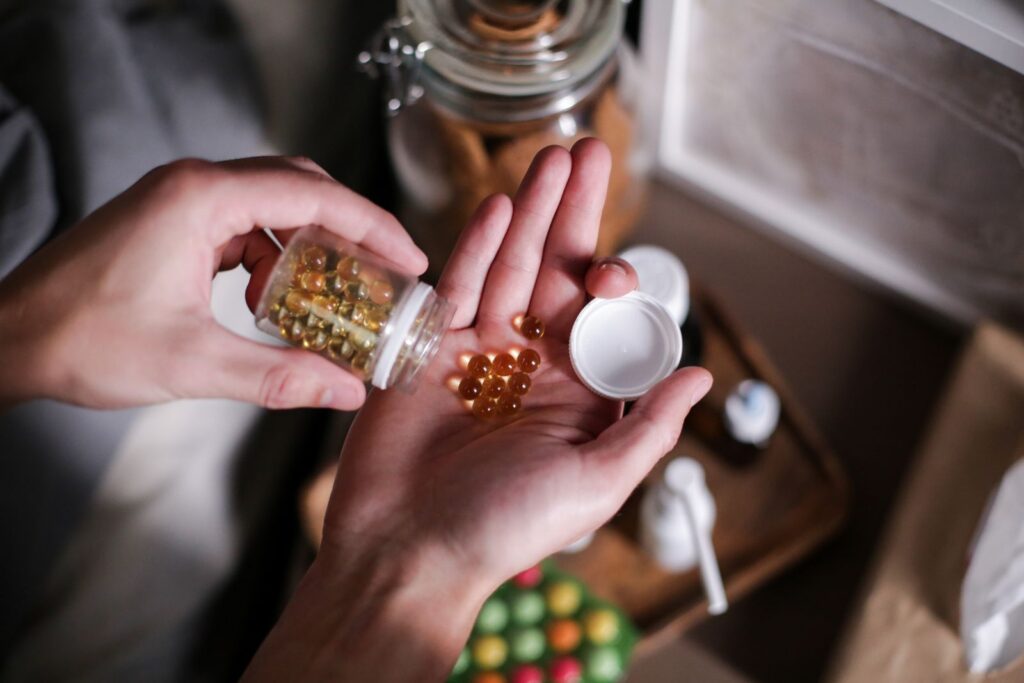 Hands cupping several unbranded supplement capsules