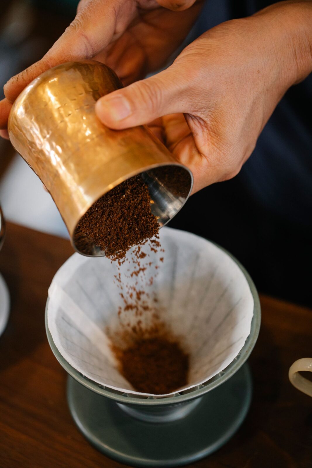 Barista pouring hot water into a coffee dripper during a pour-over brew
