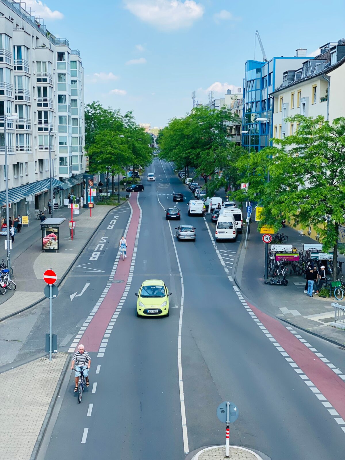 Aerial view of an urban street with cars and cyclists sharing the road in a dedicated bike lane