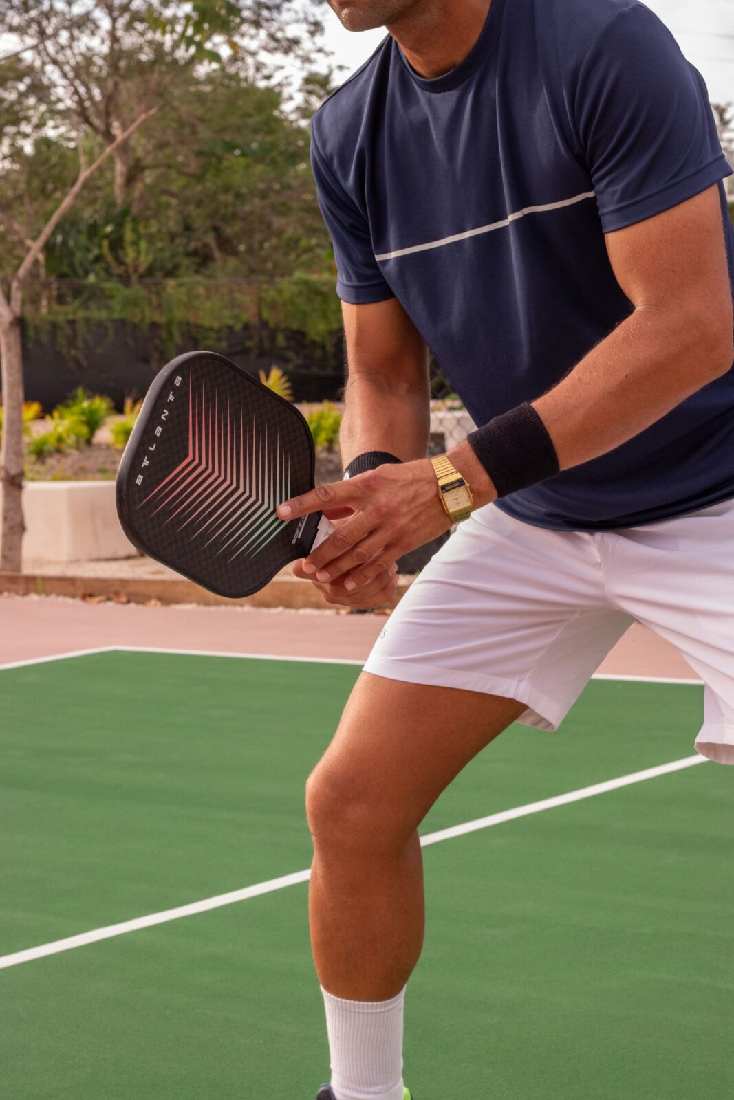 A player swinging a pickleball paddle to return a shot on an outdoor court