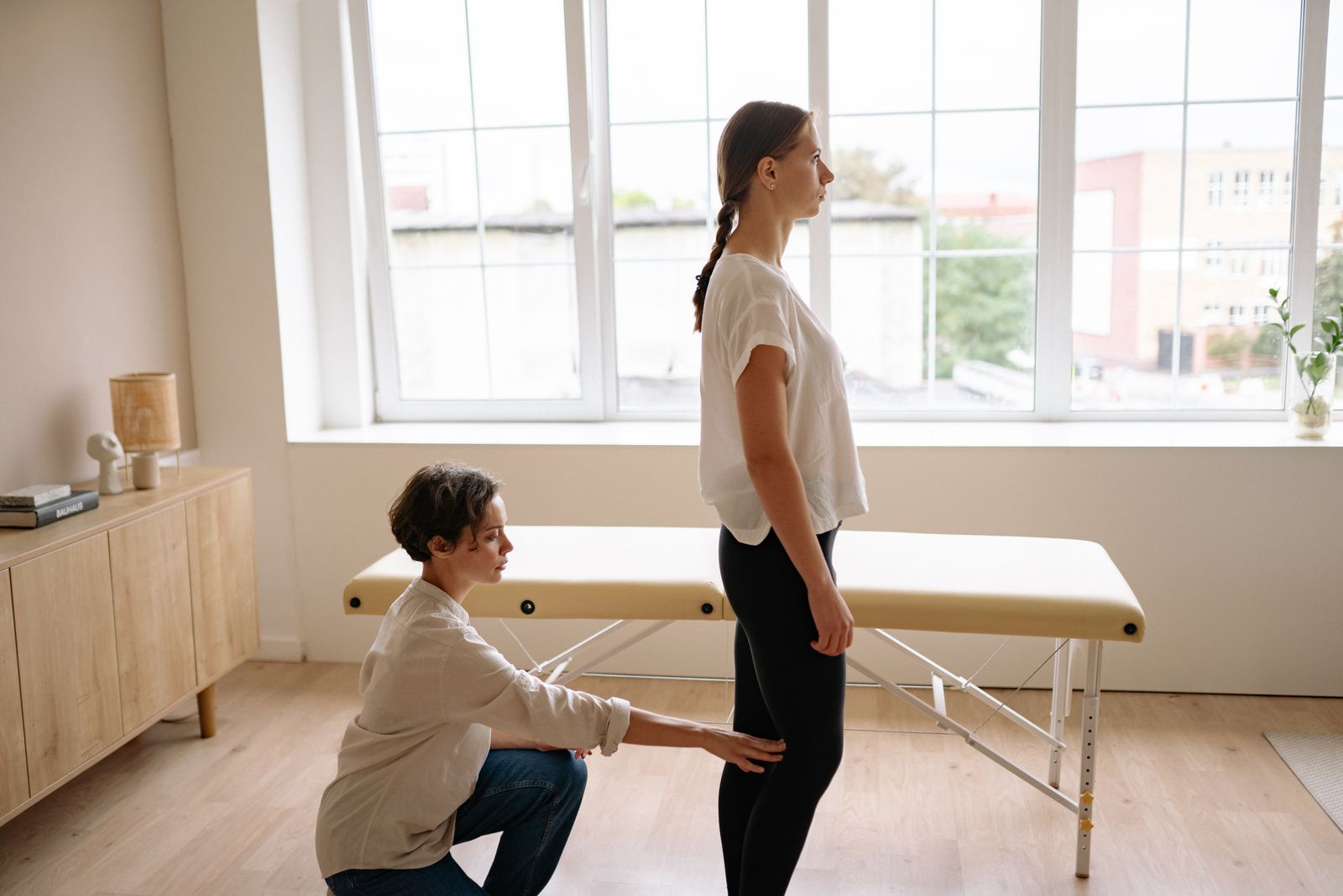 Physiotherapist assessing a client's posture during a clinical evaluation