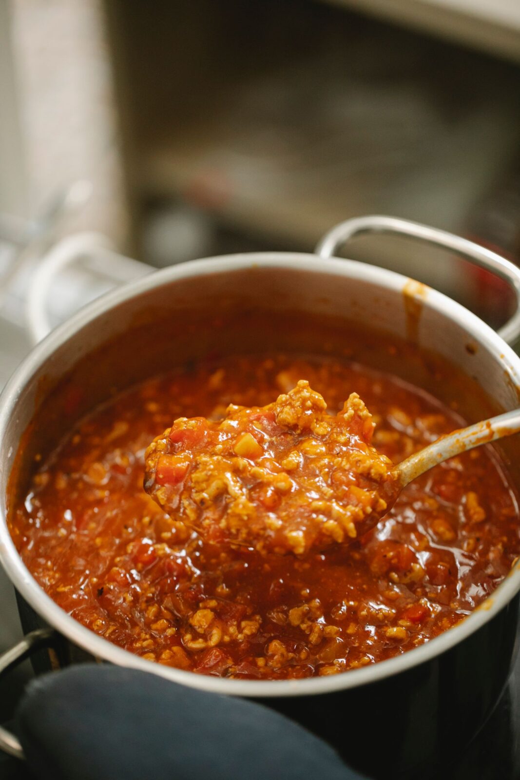 Bolognese sauce simmering in a ceramic-coated saucepan on the stove